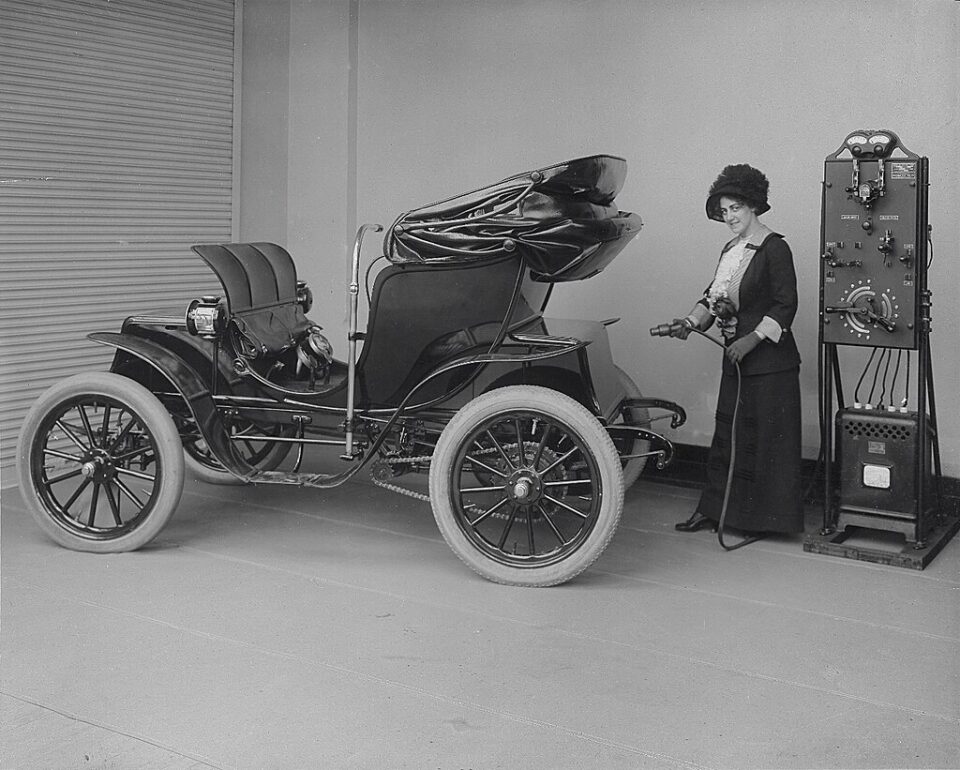 Femme branchant une recharge à une voiture électrique (1912)